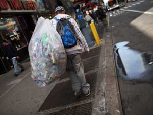 Jovem recolhe latas em Nova York, em foto de arquivo (Foto: AFP)