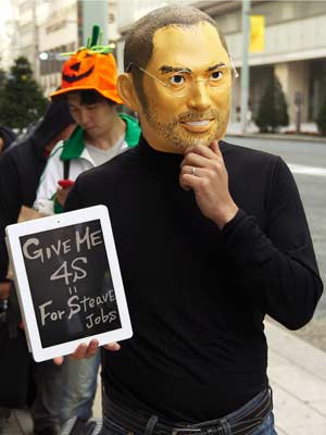 Homem usa máscara do fundador da Apple, Stevie Jobs, em fila no Japão. (Foto: Kim Kyung-Hoon/Reuters)