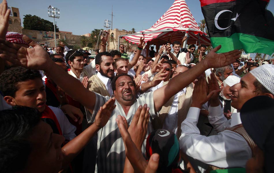 Líbios comemoram nesta sexta-feira (21) na Praça dos Mártires, em Trípoli, a morte do ex-ditador Muammar Kadhafi.