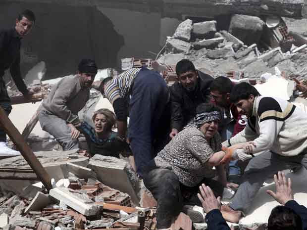 Feridos são retirados de prédios em escombros na cidade de Van após o terremoto deste domingo (23) (Foto: Reuters)