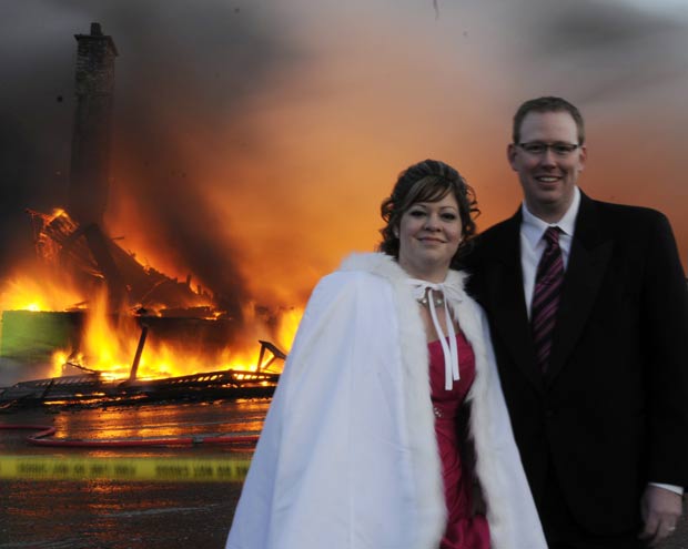 Mike e Nancy Rogers posam diante do prédio em chamas onde o casamento seria realizado. (Foto: Nicholas Augustus/Canadian Press/AP)