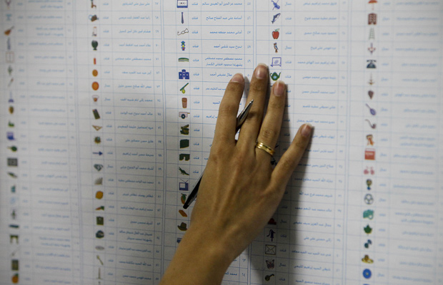 Eleitora observa cédula durante a votação nesta segunda-feira (28) no Cairo (Foto: AP)