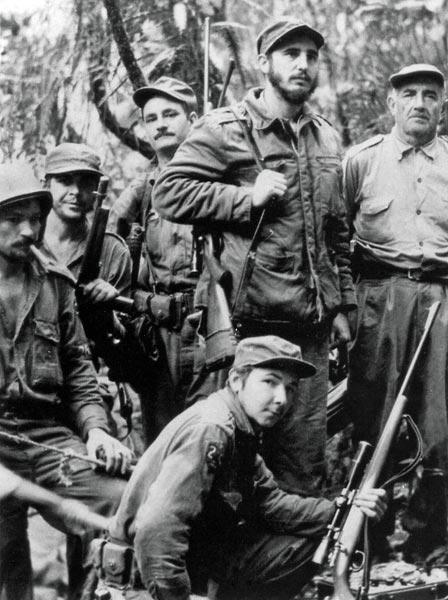 1957 - Armado, Fidel (ao centro, em pé) é visto com companheiros da guerrilha que lutou pelo poder de Cuba, entre eles o irmão Raúl Castro (baixo) e Che Guevara (segundo da esquerda para a direita)