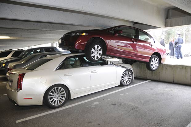 Motorista pisou no acelerador em vez do freio e estacionou em cima de outro veículo. (Foto: Wellesley Police Department/AP)