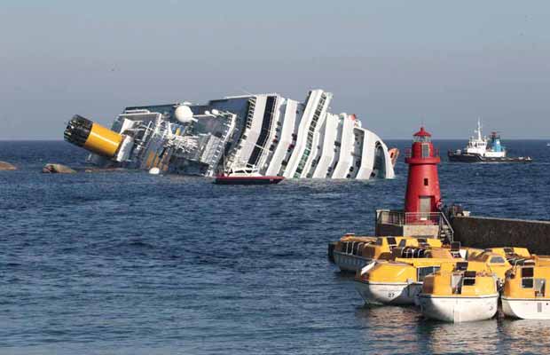 Navio parcialmente submerso após o acidente é visto na manhã deste sábado (14) próximo á ilha de Giglio, na costa da Toscana (Foto: AP)