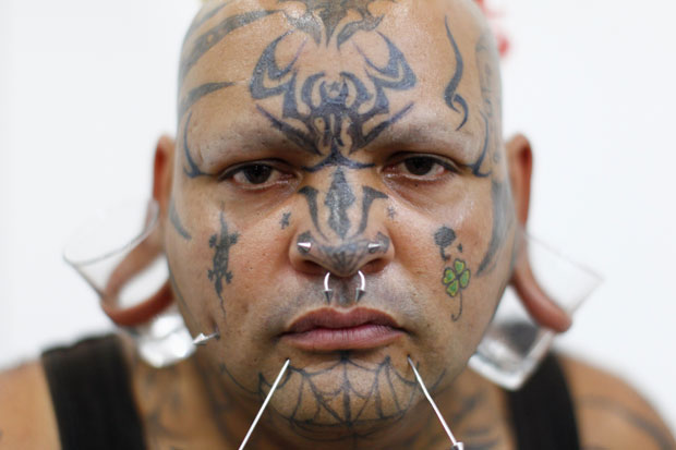 Com pequenos copos no lugar de alargadores nas orelhas, Constantino Quintero também foi ao evento de tatuagem em Caracas (Foto: Jorge Silva/Reuters)
