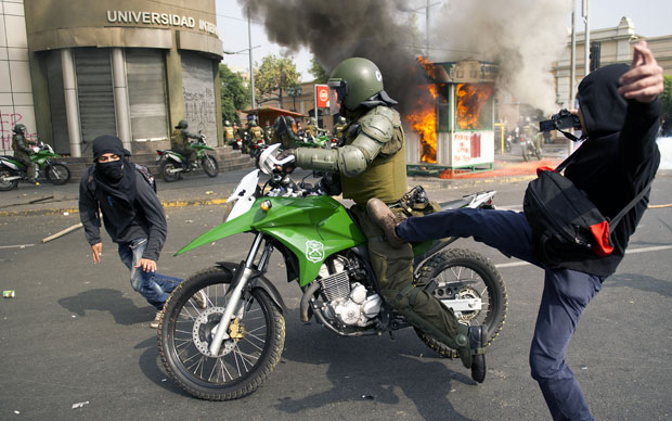 Manifestantes entram em confronto com a polícia nas ruas de Santiago (Foto: AFP)