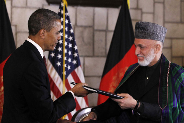 Obama e Karzai trocam os documentos assinados em Cabul (Foto: Charles Dharapak/AP)