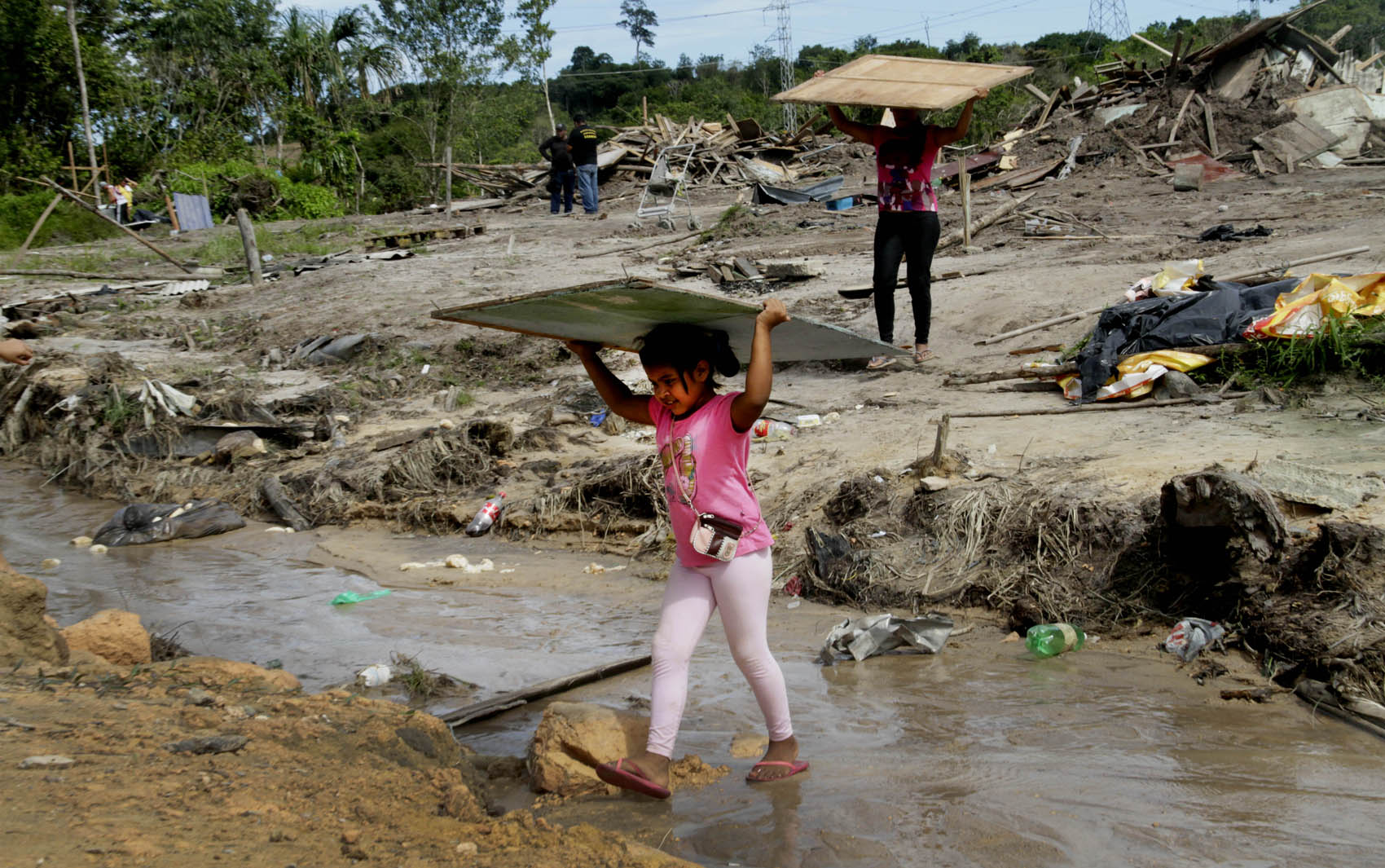 Menina carrega pedaços de um barraco depois da reintegração de posse em um terreno invadido na zona norte de Manaus nesta segunda (25). Cerca de três mil famílias foram retiradas do local conhecido como 'Comunidade Nobre'.