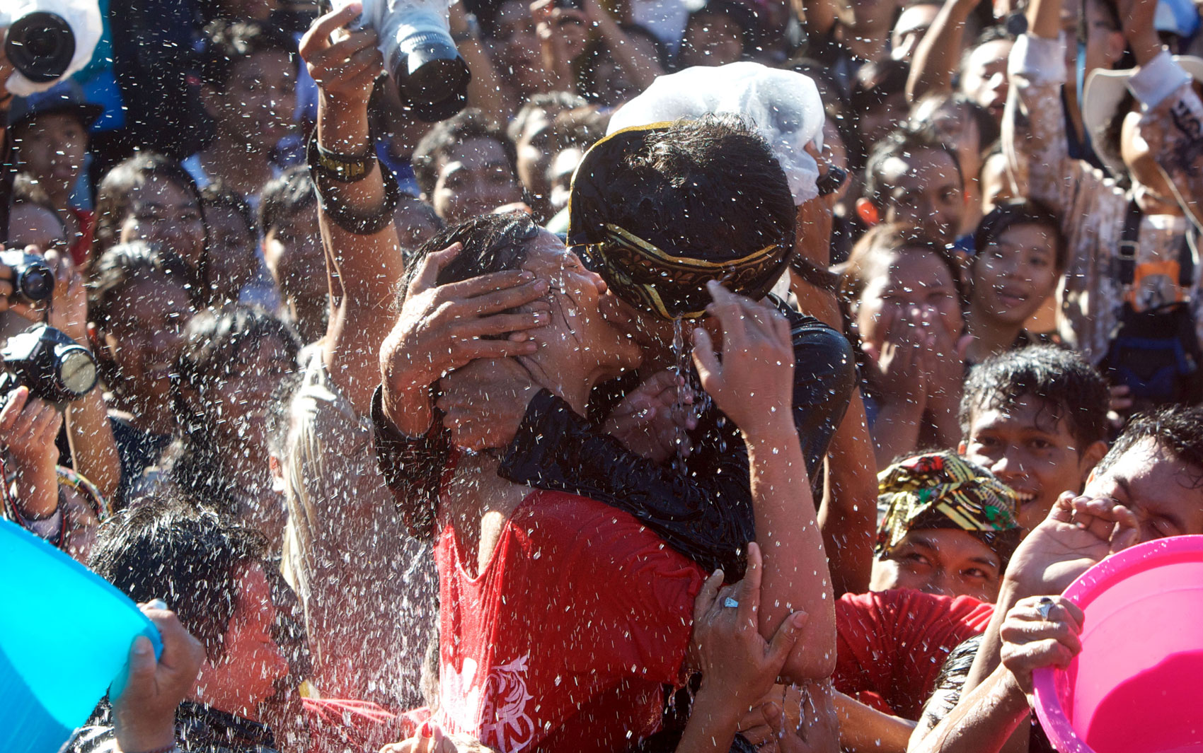 Casal se beija em meio à água atirada pela multidão no festival do beijo Omed Omedan, em Denpasar, na ilha de Bali, Indonésia. Os moradores acreditam que o festival anual garante saúde e boa sorte aos seus participantes.