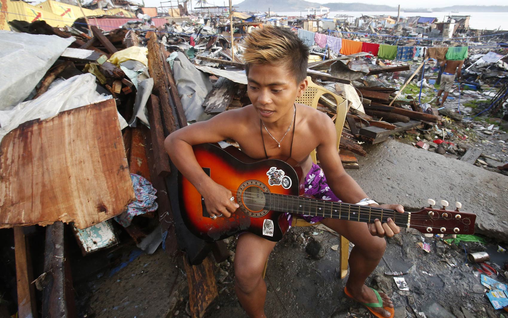 22/11 - Jovem toca violão em meio aos destroços de um bairro residencial atingido pelo supertufão Haiyan em Tacloban