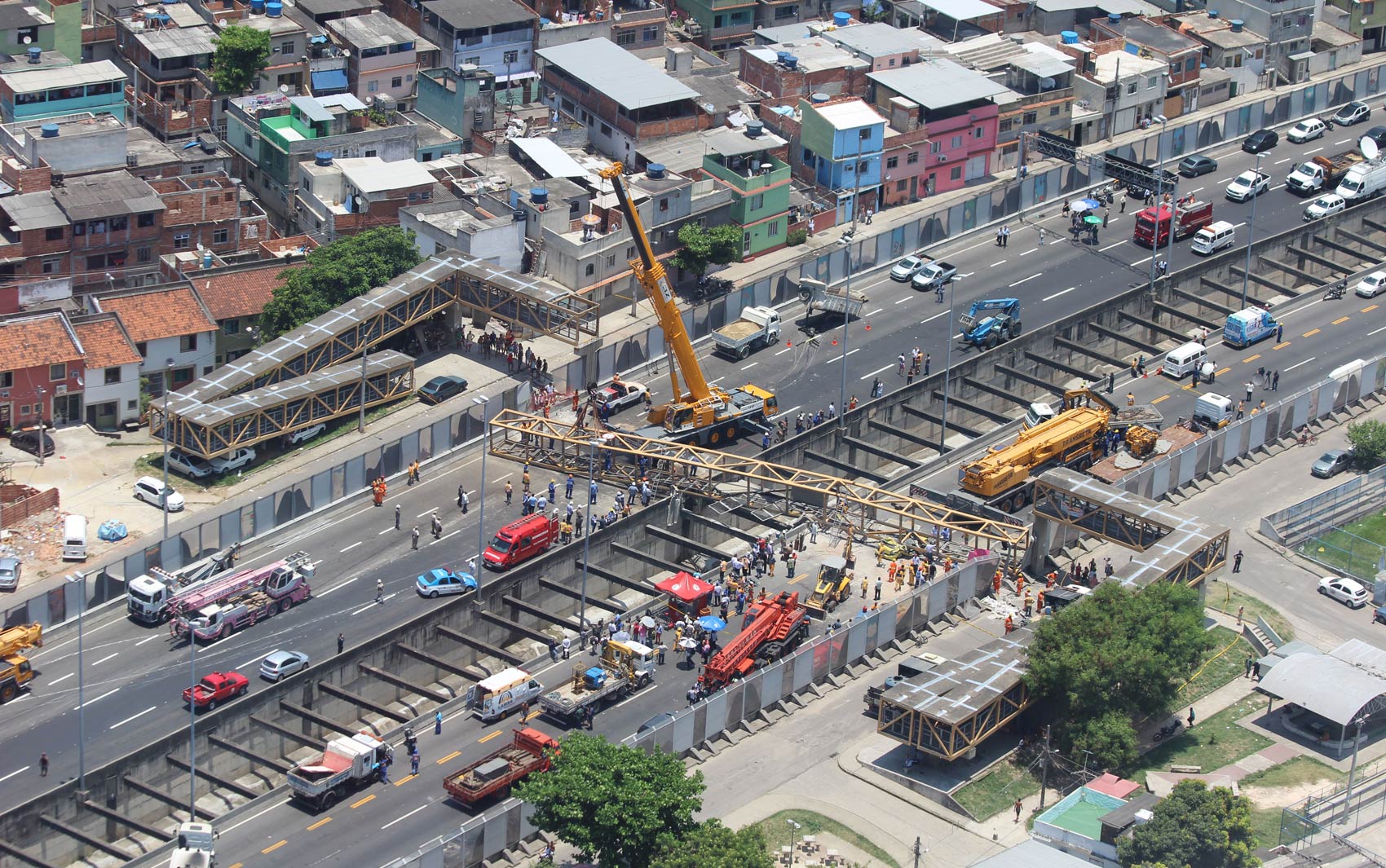 Imagem aérea mostra gruas sendo usadas para retirar a estrutura da passarela e os veículos atingidos das pistas da Linha Amarela