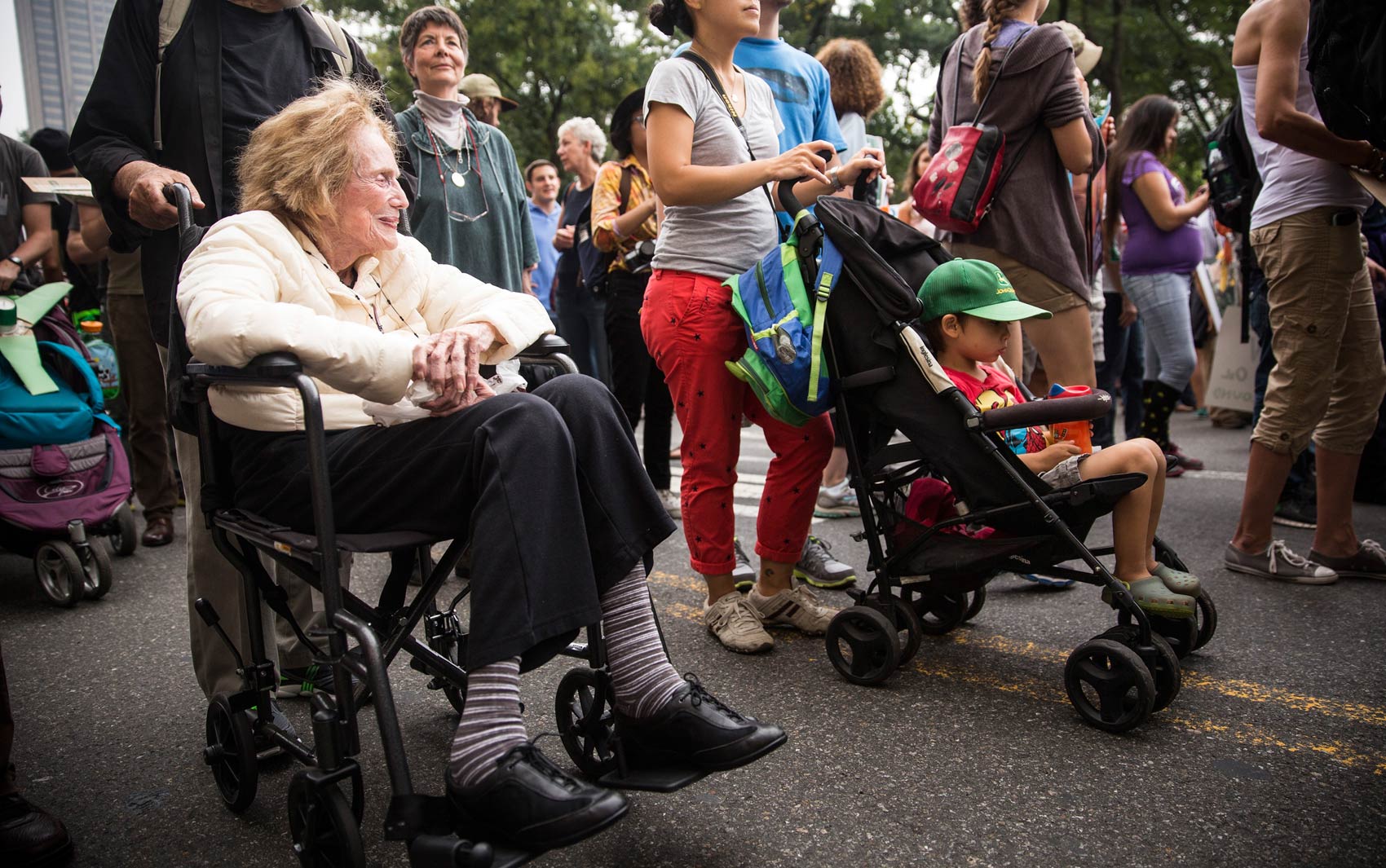 Idosa de cadeira de rodas e menino em um carrinho de bebê participam da Marcha Popular pelo Clima em Nova York