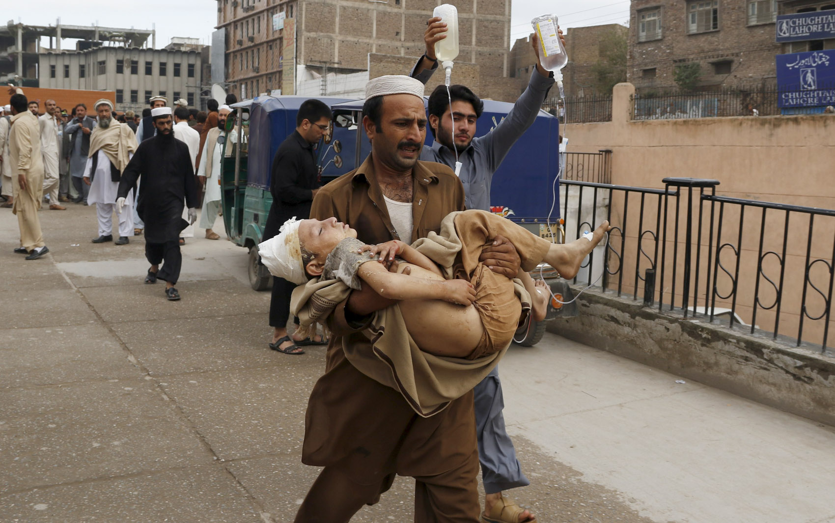 Um homem carrega um menino ferido até o hospital Lady Reading em Peshwar, no Paquistão, após forte terremoto na região